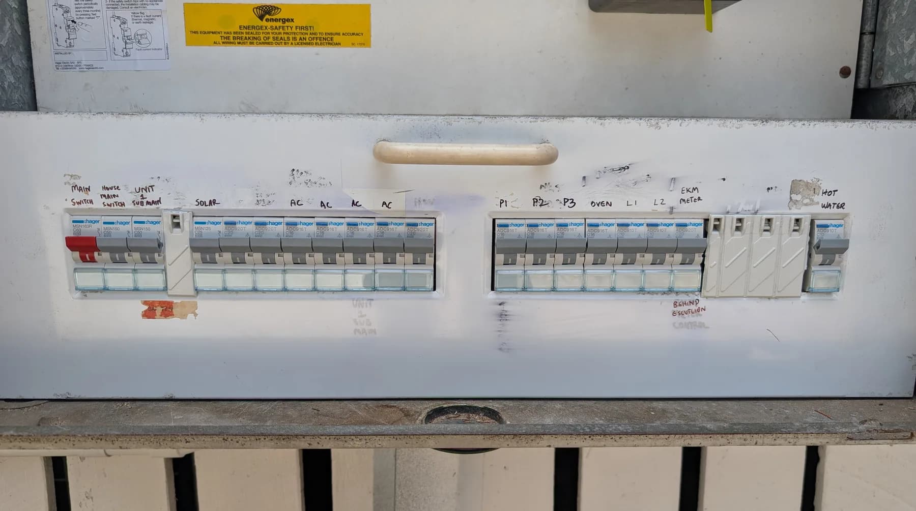 An open residential switchboard with a row of circuit breakers