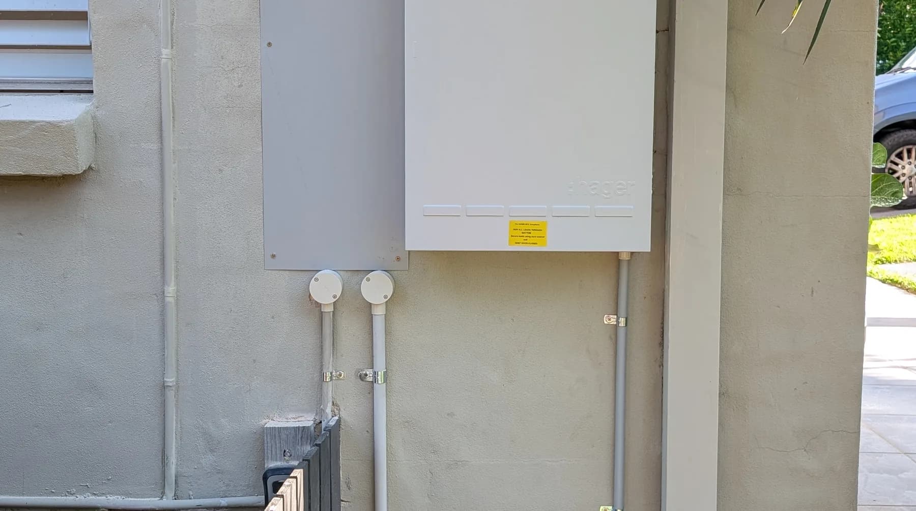 A supply and switchboard enclosure mounted on the exterior wall of a home