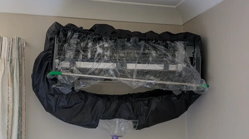 An old split-system indoor unit wrapped and ready to come off the wall