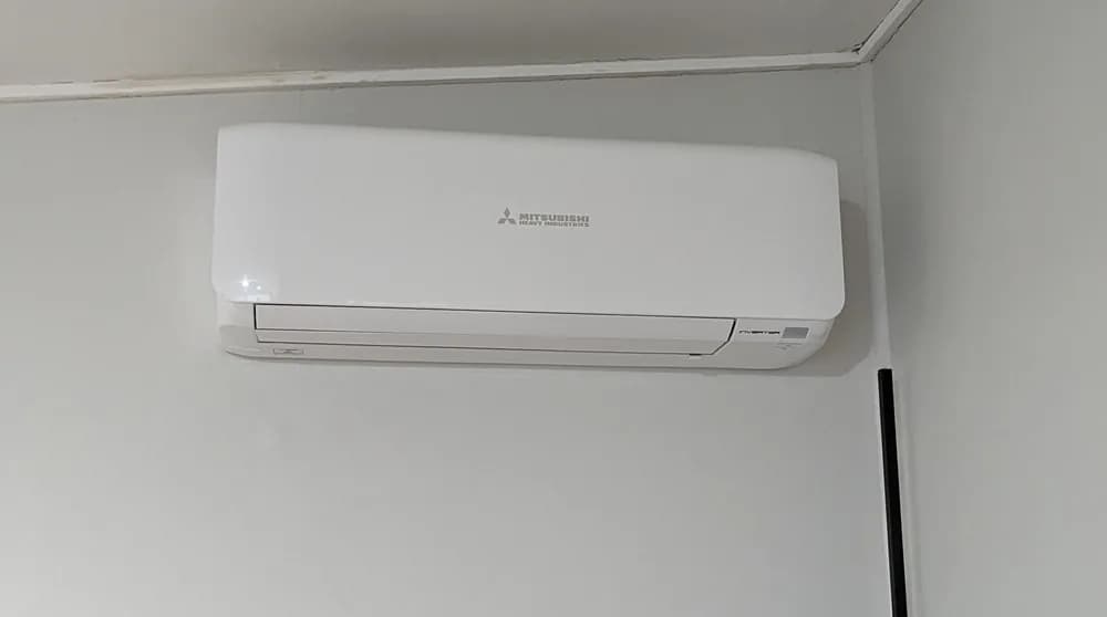 A split-system head unit mounted on a living room wall