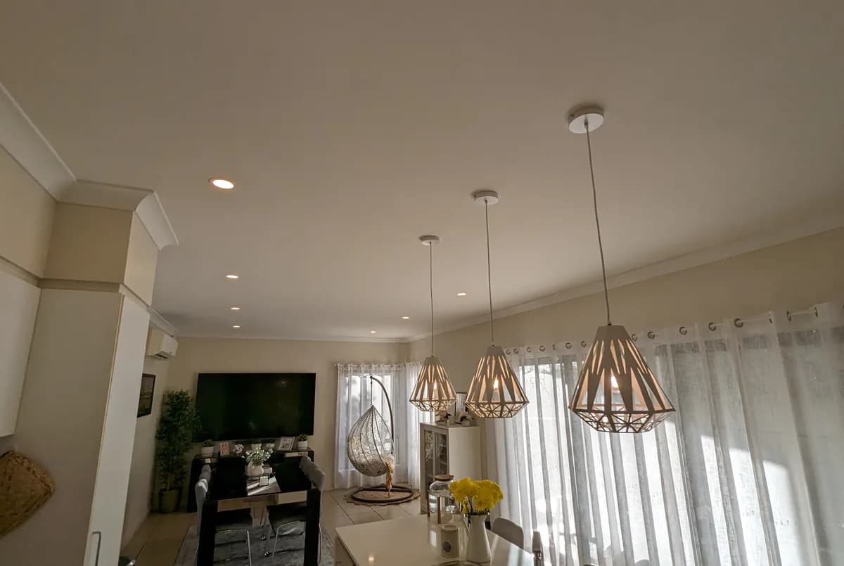A Brisbane kitchen and dining space lit by pendant lights above the bench
