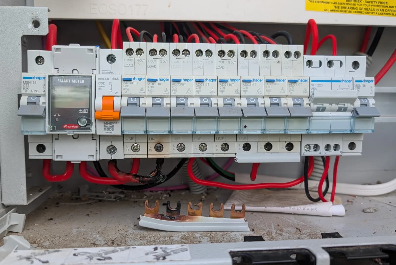 An open residential switchboard showing a row of labelled circuit breakers