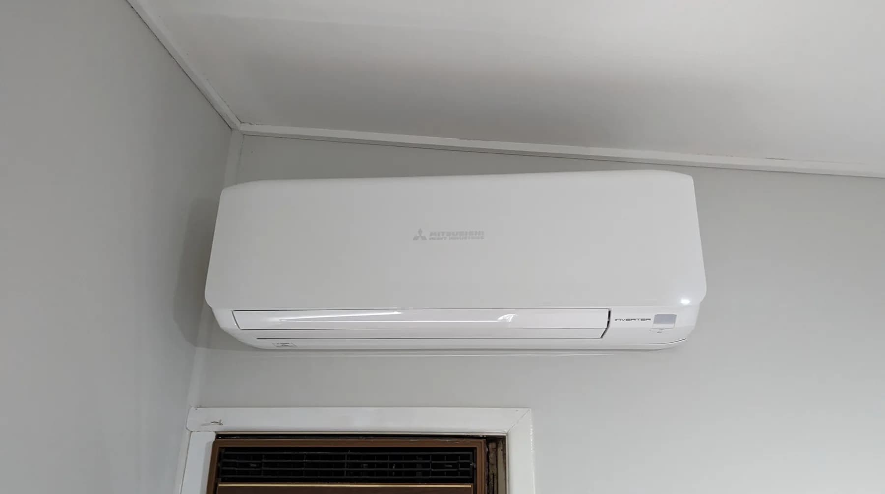 A split-system head unit mounted high on a living room wall