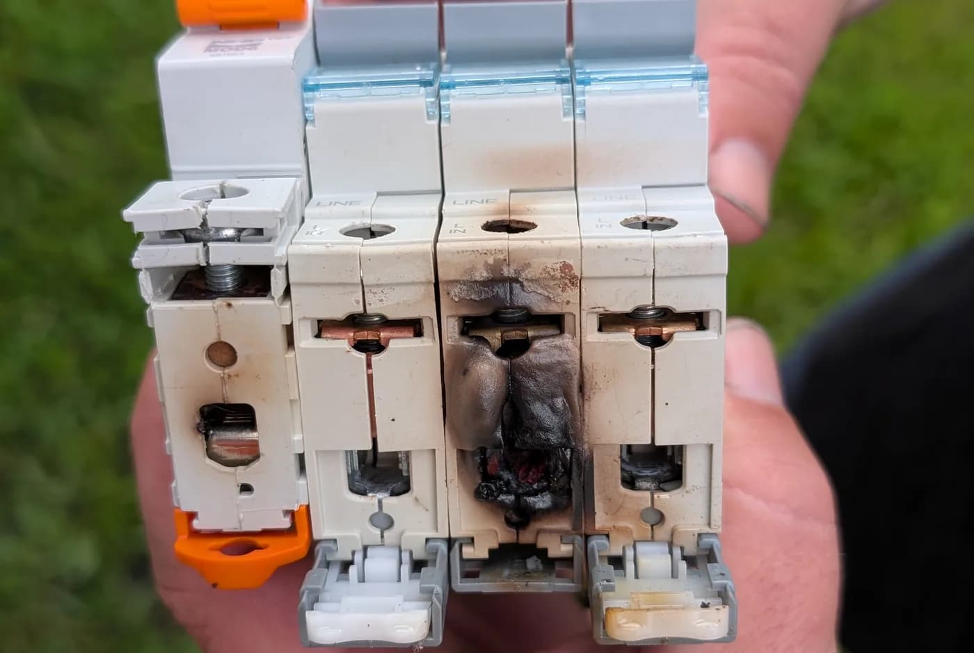 Burnt-out circuit breakers held in hand after a fault