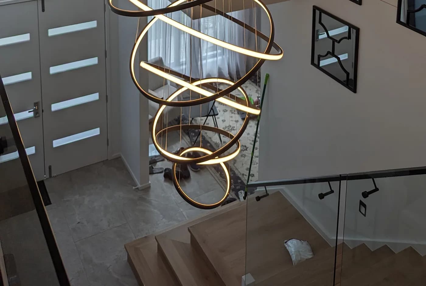 A spiral LED pendant light hanging in a stairwell void