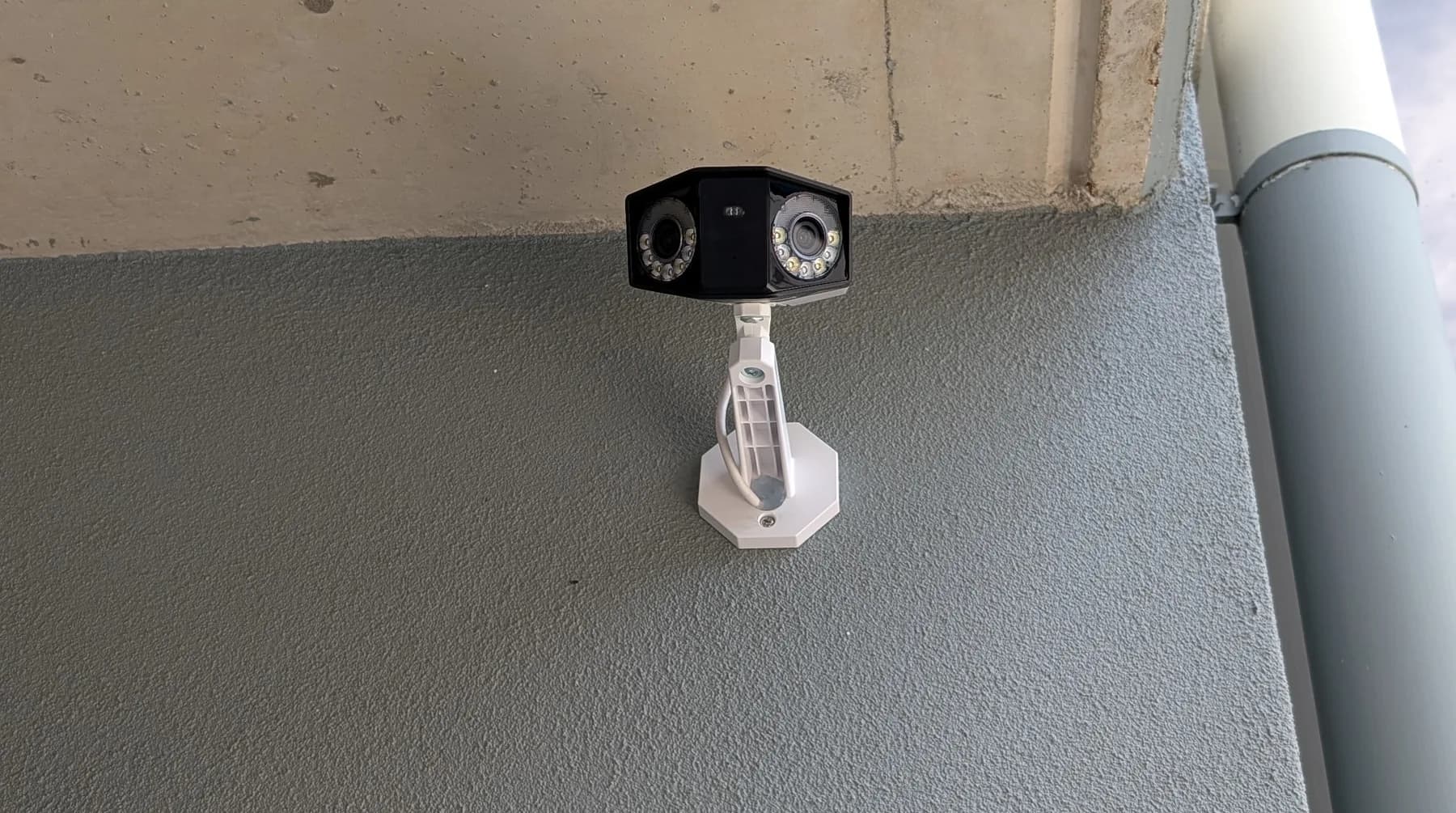 A security camera mounted under the eave of a home