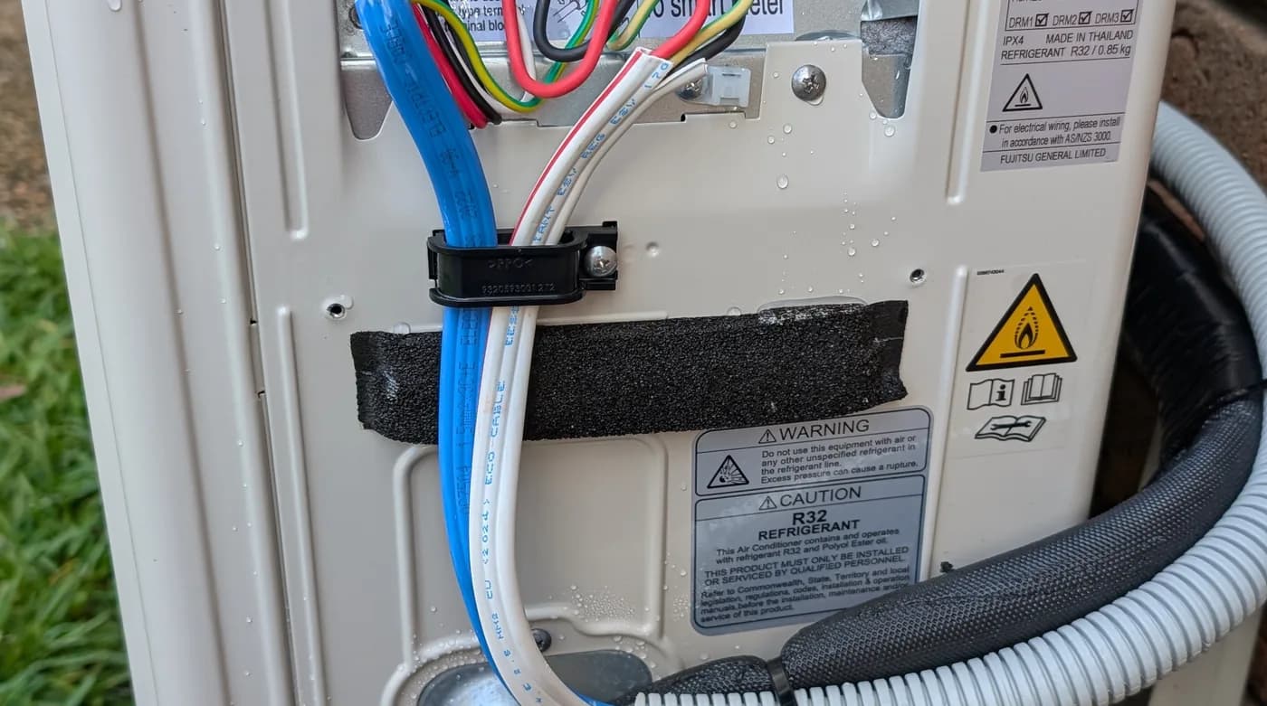 An air conditioning isolator switch wired beside a condenser unit