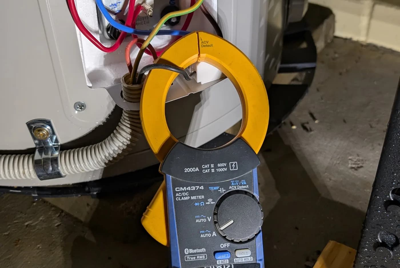 A clamp meter testing the terminals inside a hot water cylinder