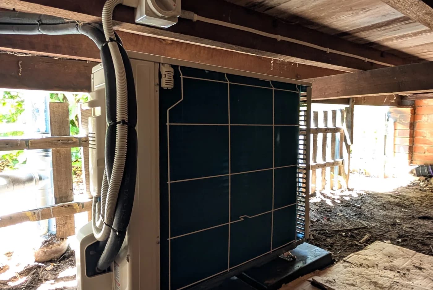 Ducting and cabling running through the roof space above a ceiling