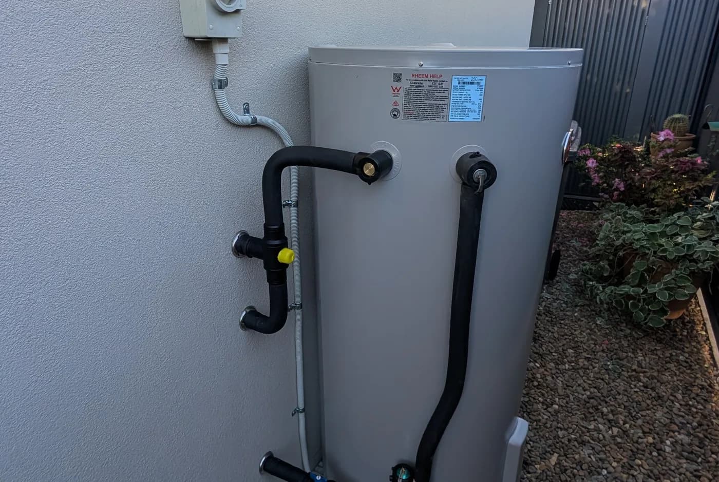 An electric hot water cylinder installed in a narrow side alcove
