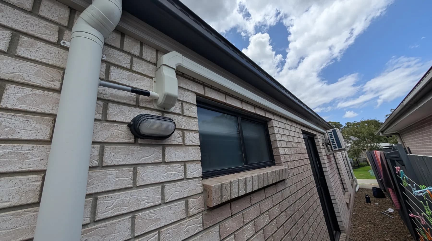 An eave-mounted light on the brick wall of a home