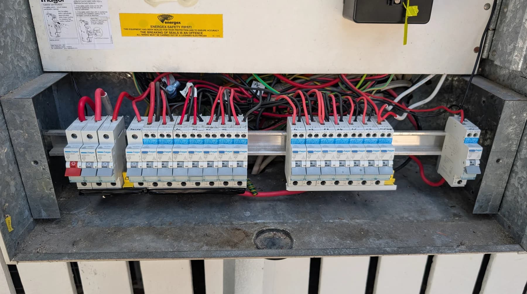 An open switchboard showing two full rows of RCBOs and their wiring