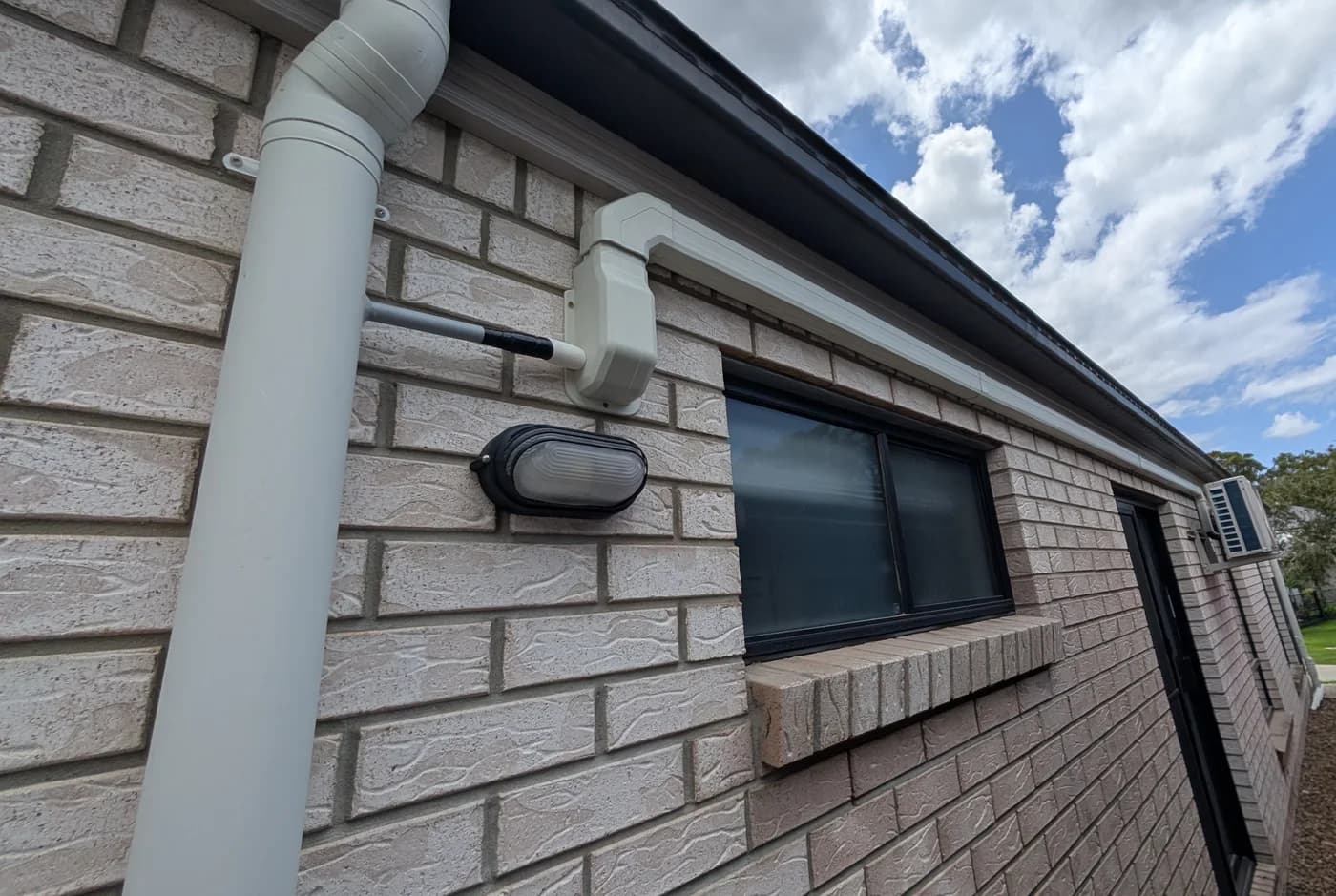 A bunker light mounted high on a brick wall under the eave